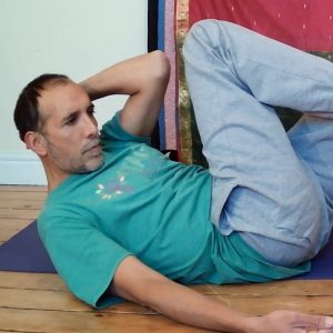 Man doing somatic movement - the diagonal arch and curl